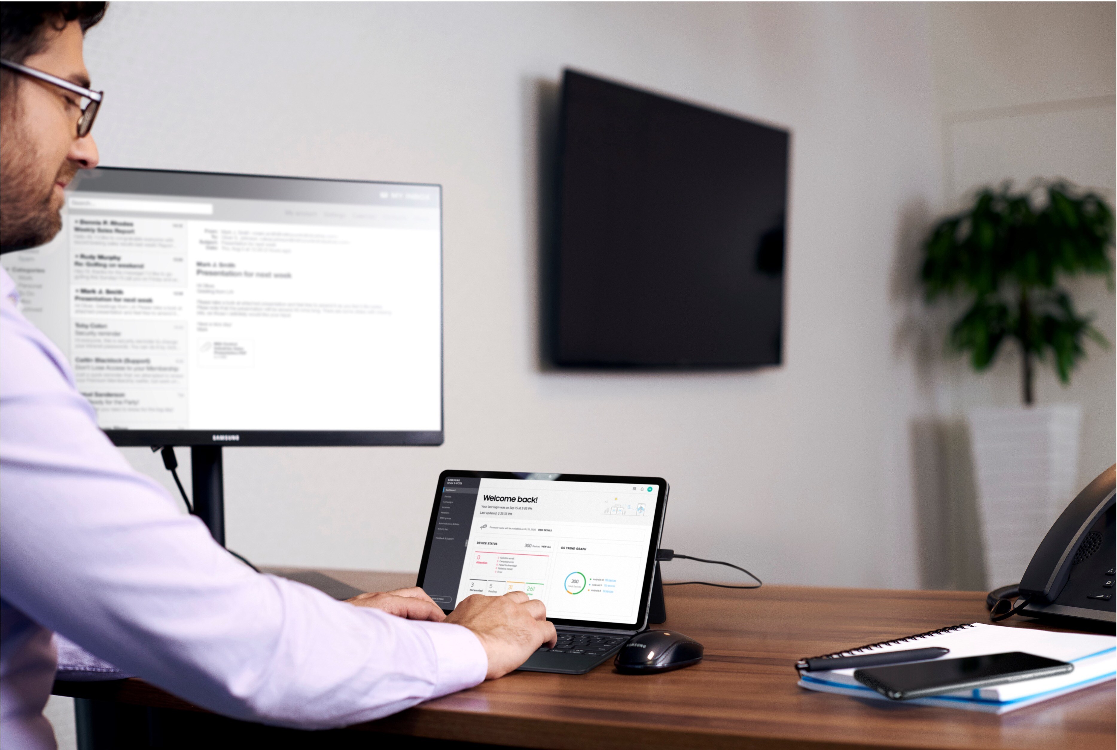 Ein Mitarbeiter, der am Schreibtisch mit verschiedenen Geräten arbeitet, die mit Samsung Know verwaltet werden.